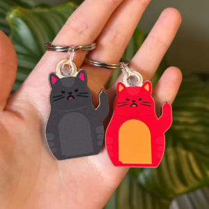Grey or red wooden keyring of cat