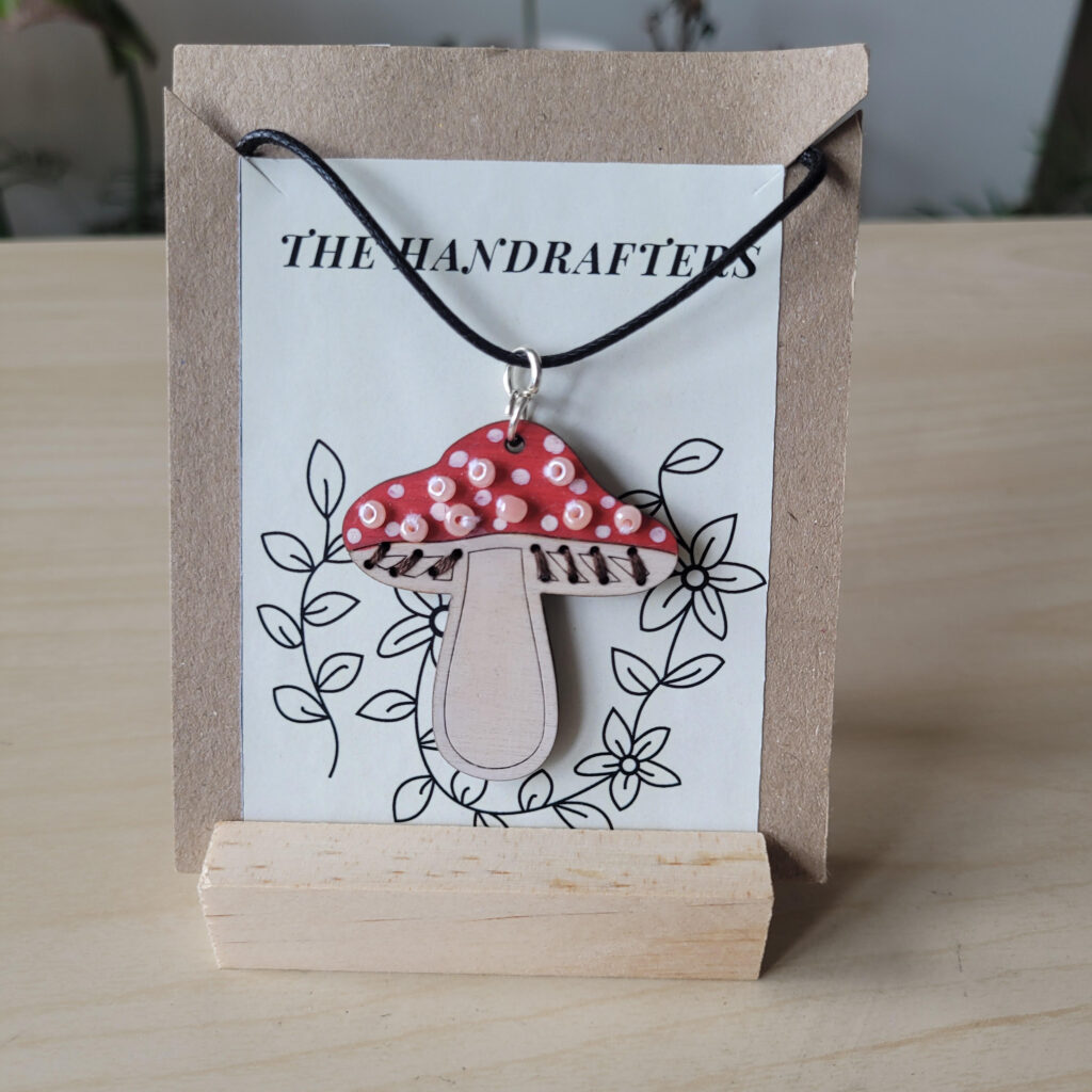 red and white mushroom shaped pendant with beads